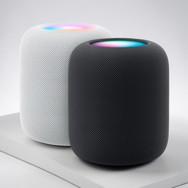 Two Apple HomePod speakers, one white and one black, displayed on a light surface with colorful lights on top.