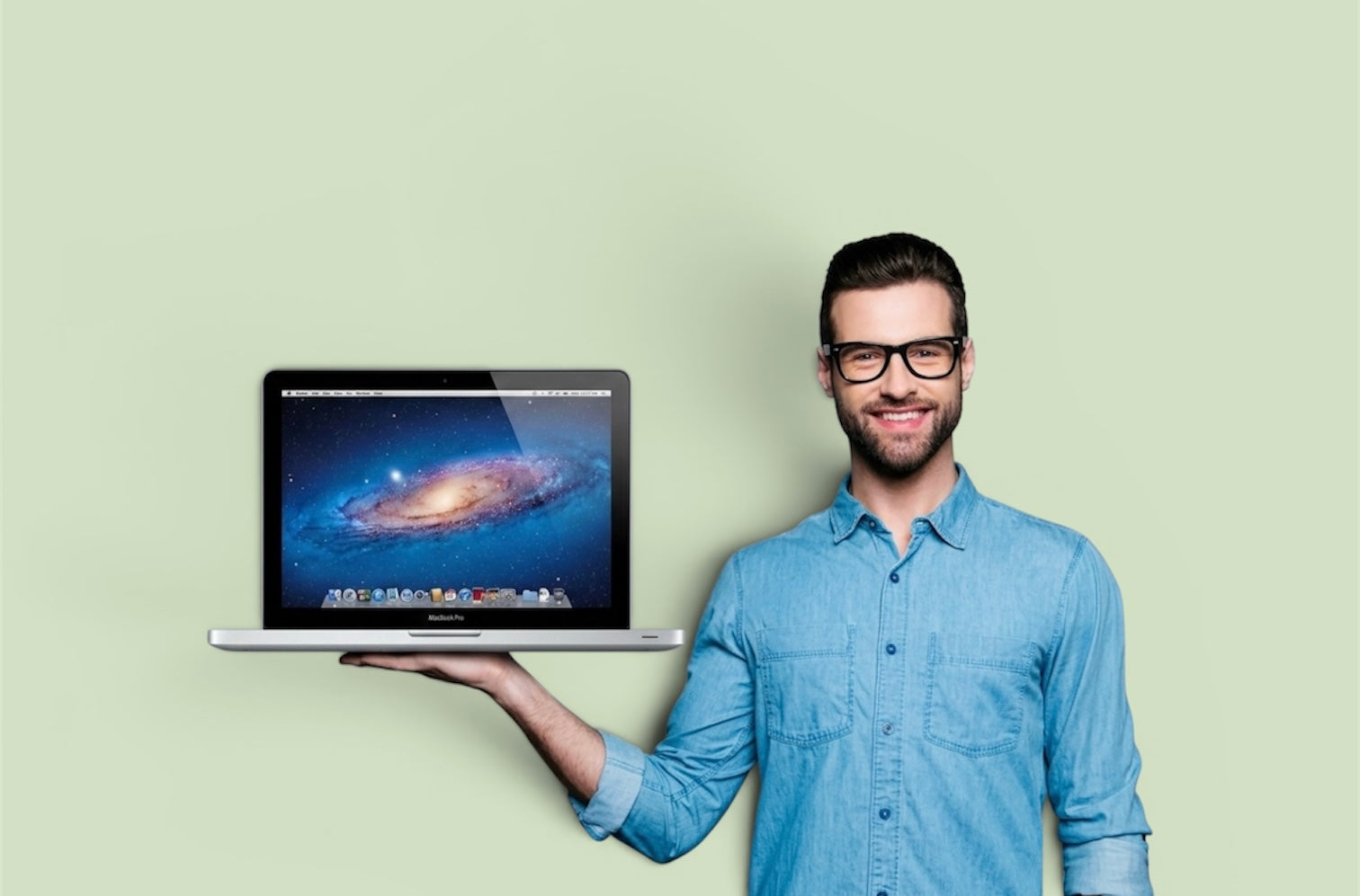 Man holding a MacBook displaying a galaxy background, representing refurbished Apple devices.