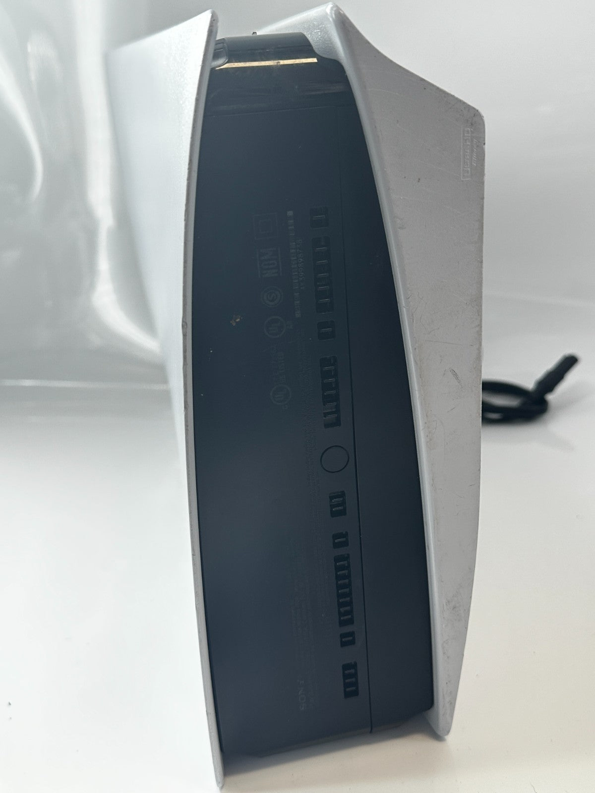 Angled view of a white and black Sony PlayStation 5 console's rear.